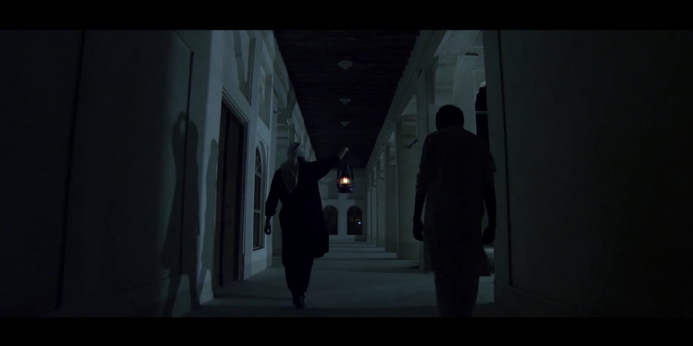 Figures walk away down the vanishing corridor into darkness.